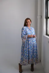 Vestido midi celeste con estampado de manchas beige, cuello mao, mangas 3/4 acampanadas y corte escalonado.