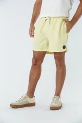 Short de baño amarillo liso, con dos bolsillos delanteros y uno trasero. Confeccionado en tela ligera de secado rápido y logo en goma.