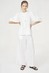 Camisa blanca de lino con cuello mao, mangas globo al codo y botones de nácar.