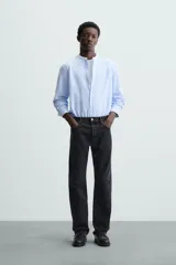 Camisa negra de lino y algodón, corte relaxed fit, cuello mao, manga larga con puños abotonados y cierre frontal con botones.