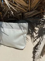 Sobre de mano plateado con detalles en yute y pulsera personalizada con la palabra "RUPIA".