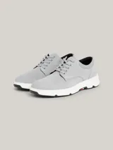 Zapatillas de corte medio color gris claro, con exterior de ante, interior de poliéster reciclado, plantilla extraíble de poliuretano y poliuretano reciclado, suela de goma y caucho, trabilla para calzar distintiva y logo de Tommy Hilfiger en bajo relieve en el lateral y la parte trasera.