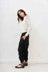 Pantalón jogger negro de nylon con elástico ancho en la cintura, puños elásticos ajustables y lazos laterales para fruncir.