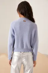 Sweater azul con cuello redondo, diseño texturizado y detalles en perlas en los hombros.