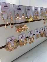 Set de aros y caravanas plateadas y doradas con diseños florales, abstractos y geométricos.