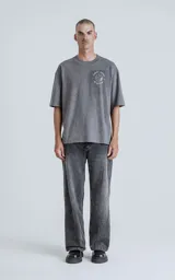 Remera gris melange de manga corta con cuello redondo y calce oversize. Estampado en el frente con una ilustración de una figura femenina y la inscripción "El Mundo".