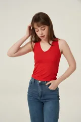 Musculosa roja de poliéster con bretel ancho, canalé, corte al cuerpo y cuello redondo.