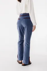 Pantalón de pana marrón con corte acampanado y abertura en el ruedo.