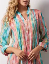 Blusa de gasa estampada multicolor, marca Ruby Rd. Tiene cuello a la base, escote en V, abertura central con botones y plisados en la parte delantera. Las mangas son 3/4 y tienen un largo regulable con presilla y botón.