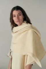 Chal unisex de lana fina sin teñir, realizado con retazos de telas diseñadas por Don Baez. Presenta una grifa de cuero aplicada.