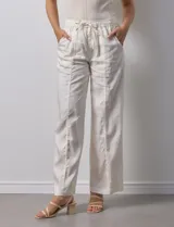 Pantalón palazzo color crudo, marca Nanette, con pretina elastizada, lazo de ajuste y bolsillos delanteros.