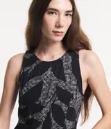Mono largo sin mangas de viscosa twill color negro con estampado de follaje en blanco. Tiene cuello redondo, cierre con botón en la espalda y bolsillos laterales.