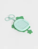 Llavero y charm pop it en forma de osito color verde agua, con detalles en blanco, naranja y violeta.