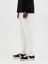 Pantalón de jogging gris claro, de algodón y poliéster reciclado, con cintura elástica ajustable con cordón, corte relajado, tiro medio y logo bordado en la pierna izquierda.