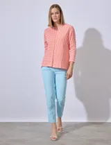 Remera de algodón con estampado a rayas horizontales y verticales en color naranja y blanco.