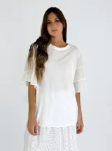 Blusa blanca de mangas cortas con volados y cuello redondo.