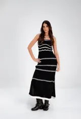 Vestido largo tejido a crochet, color negro con rayas horizontales blancas.