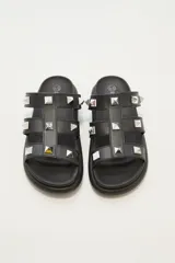 Sandalias negras con plataforma y tiras gruesas con apliques de tachas piramidales plateadas.