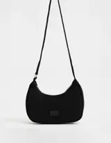 Bandolera tipo baguette de tela deportiva color negro con asa de hombro y cierre superior.