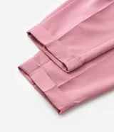 Conjunto de sastrería color rosa, compuesto por un blazer cruzado de corte holgado y un pantalón de vestir tiro alto, corte carrot con pinzas y puños doblados.