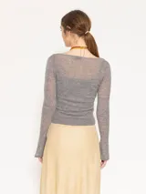 Sweater gris compuesto por un top inferior de breteles y un sweater superior de manga larga con escote en V cruzado. Ambas piezas están confeccionadas en tejido liviano de lana mezclada.