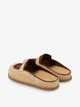 Mules artesanales tejidas a mano en raffia color beige y negro, con diseño cómodo y flexible, suela liviana y estilo relajado.