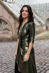 Vestido verde metalizado con escote en V pronunciado, mangas 3/4 y frunce en la cintura.