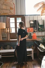 Vestido largo de tejido acanalado, con diseño bicolor vertical: mitad negro y mitad beige claro. Tiene mangas cortas y escote en V.