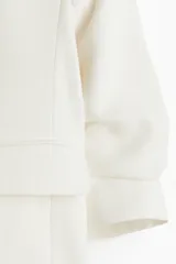 Blazer entallada color blanco, confeccionada en mezcla de viscosa. Modelo con hombreras, solapas de muesca, mangas tres cuartos fruncidas y bolsillos delanteros con solapa. Sin cierre y forrado.
