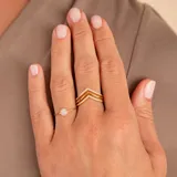 Anillo dorado con diseño de doble V invertida, con incrustaciones de circonias. Fabricado en oro 9k.