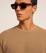 Suéter de punto color gris, con cuello redondo, manga larga y textura maquinetada.