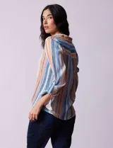 Camisa de gasa estampada a rayas verticales de color celeste, blanco, naranja y marrón. Tiene cuello con solapa, escote en V, abertura central con botones, bolsillo aplicado en el pecho y terminación anudada en la parte delantera.