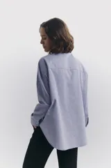Camisa celeste de corte oversize, confeccionada en algodón 100%.