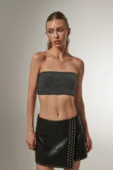 Top cropped negro de poliamida y lurex, al cuerpo, con elástico y cuello strapless.