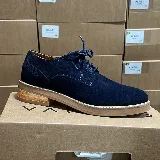 Zapato acordonado de cuero azul marino con suela de madera clara.