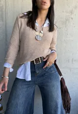 Sweater beige de hilo con cuello redondo y mangas largas.