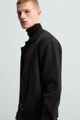 Cárdigan negro de punto con cuello solapa, manga larga y cierre frontal con botones.