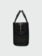 Bolso tote pequeño Marc Jacobs, tejido en color negro, con manijas cortas y correa larga ajustable. Estampado frontal con el texto "THE TOTE BAG MARC JACOBS" en color blanco.