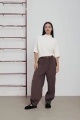 Pantalón marrón de corte amplio con cintura elastizada y cinturón marrón.