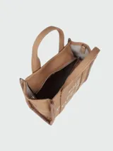 Bolso tipo tote pequeño de Marc Jacobs confeccionado en tejido jacquard color tostado. Presenta el texto 'THE TOTE BAG MARC JACOBS' bordado en el frente en contraste, asas de mano superiores y cintas laterales con inscripciones de la marca.