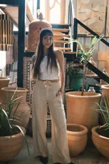 Pantalón de vestir negro de tiro alto, corte recto y pierna ancha. Presenta pliegues frontales y bolsillos laterales.