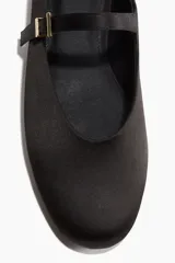 Ballerinas negras de punta almendrada con tira sobre el empeine y hebilla metálica dorada. Taco bajo.