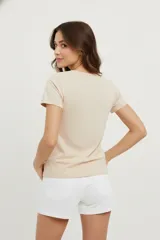 Remera color rosa pálido de algodón con cuello en V y estampado de un corazón formado por flores y hojas en tonos borgoña.