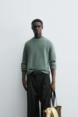 Sweater azul de punto con textura, corte holgado, cuello redondo y mangas largas con puños acanalados.