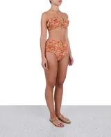 Calzón de bikini tiro alto con estampado floral en tonos naranja, amarillo y marrón.