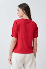 Remera roja de algodón con cuello redondo y mangas cortas con detalle de broderie. Corte clásico.