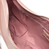 Bandolera color nude de material símil cuero, con forma curva y cierre superior metálico. Presenta un bolsillo interno con cierre y herrajes plateados. Incluye correa regulable para usar al hombro o cruzada.