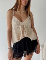 Blusa color crema con breteles finos, escote en V y bordados florales con cuentas.