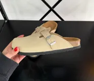 Zuecos color beige con plantilla de corcho y hebilla metálica ajustable.