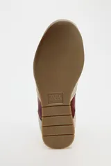 Zapatillas deportivas con combinación de colores blanco, beige y bordó. Suela en contraste color caramelo. Cierre mediante cordones.